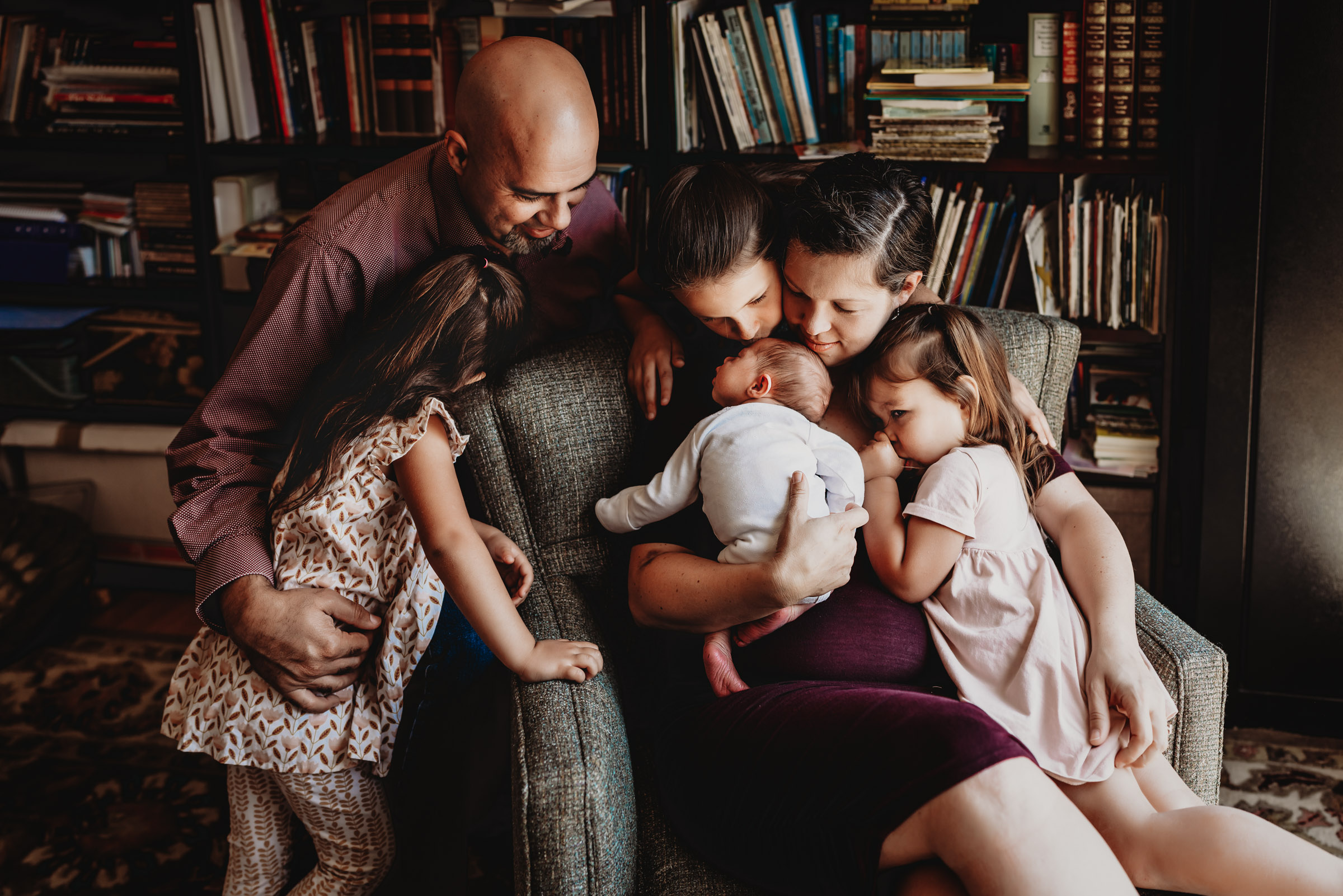 Family of 6 gathered around a their newborn baby during a San Diego in-home lifestyle newborn photo session by Love Michelle Photography. 