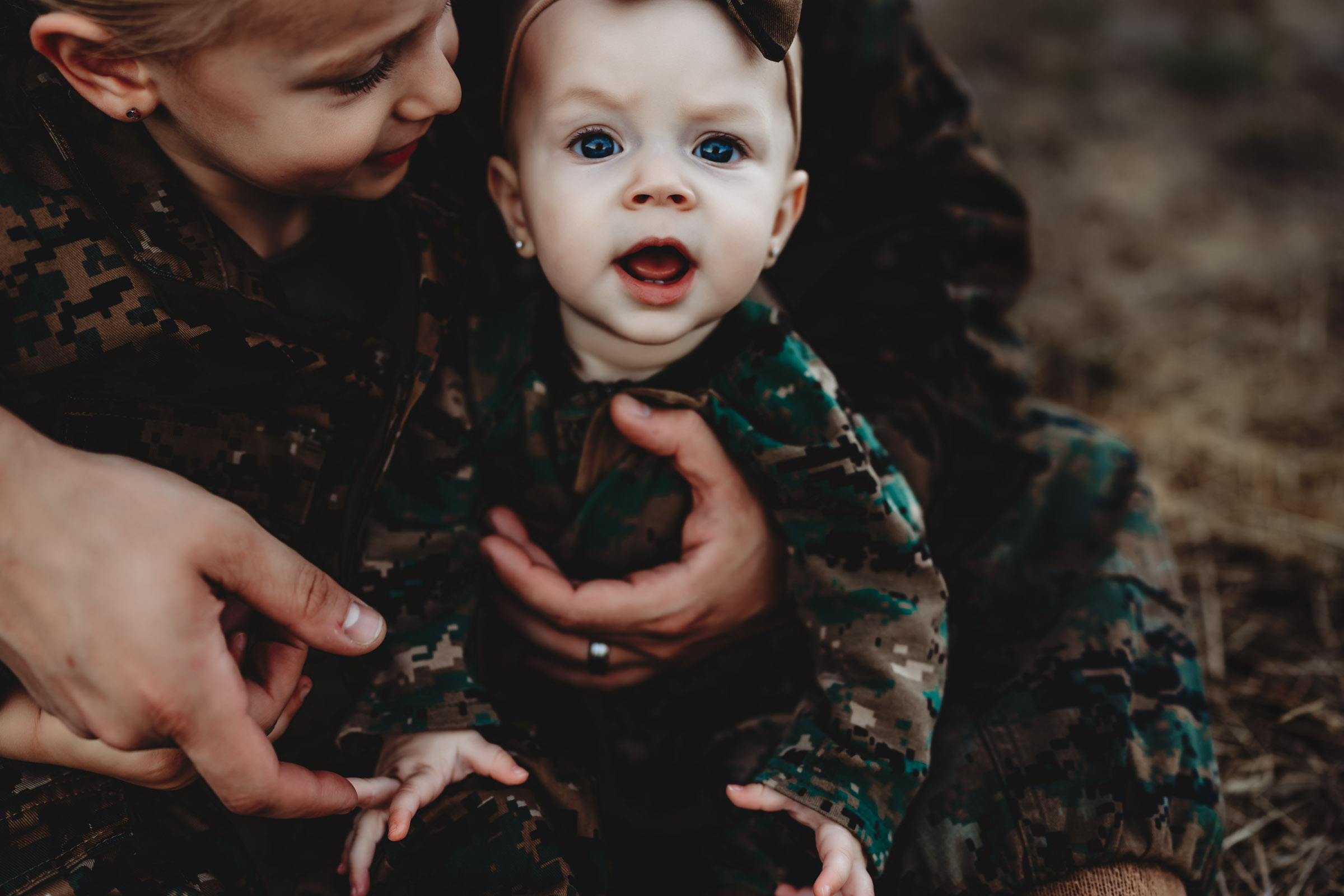 A baby wearing a Marine Corp uniform during a San Diego family photo session.