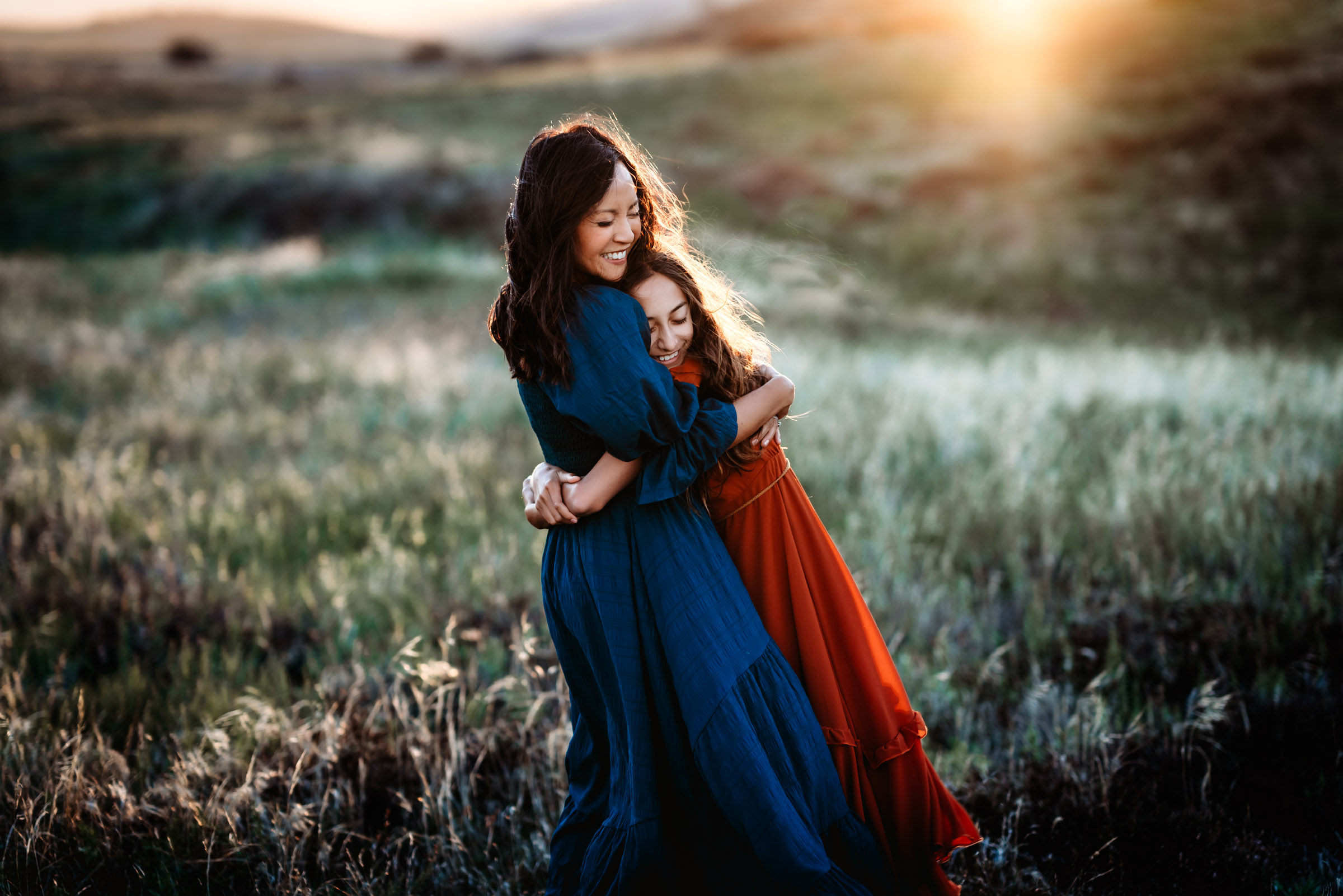 Mother and daughter hugging each other and smiling during a family photography session on Mt. Laguna. 