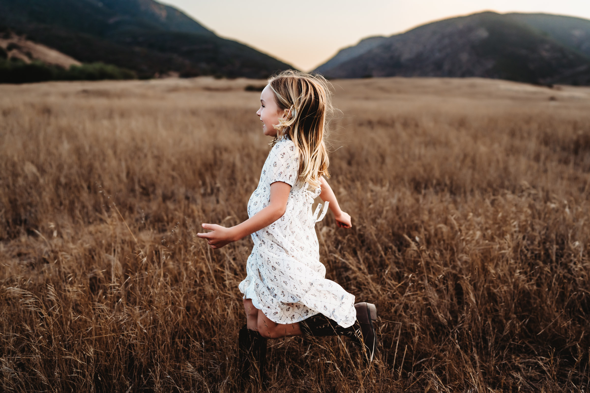 Little girl running in a field during a lifestyle family photography session at Mission Trails Regional Park 
