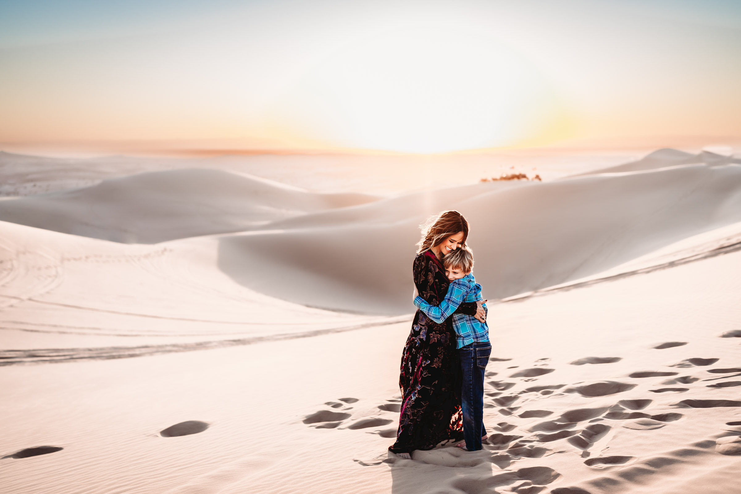 Mom and son hugging on the Imperial Sand Dunes near Glamis during a San Diego lifestyle family photography session.