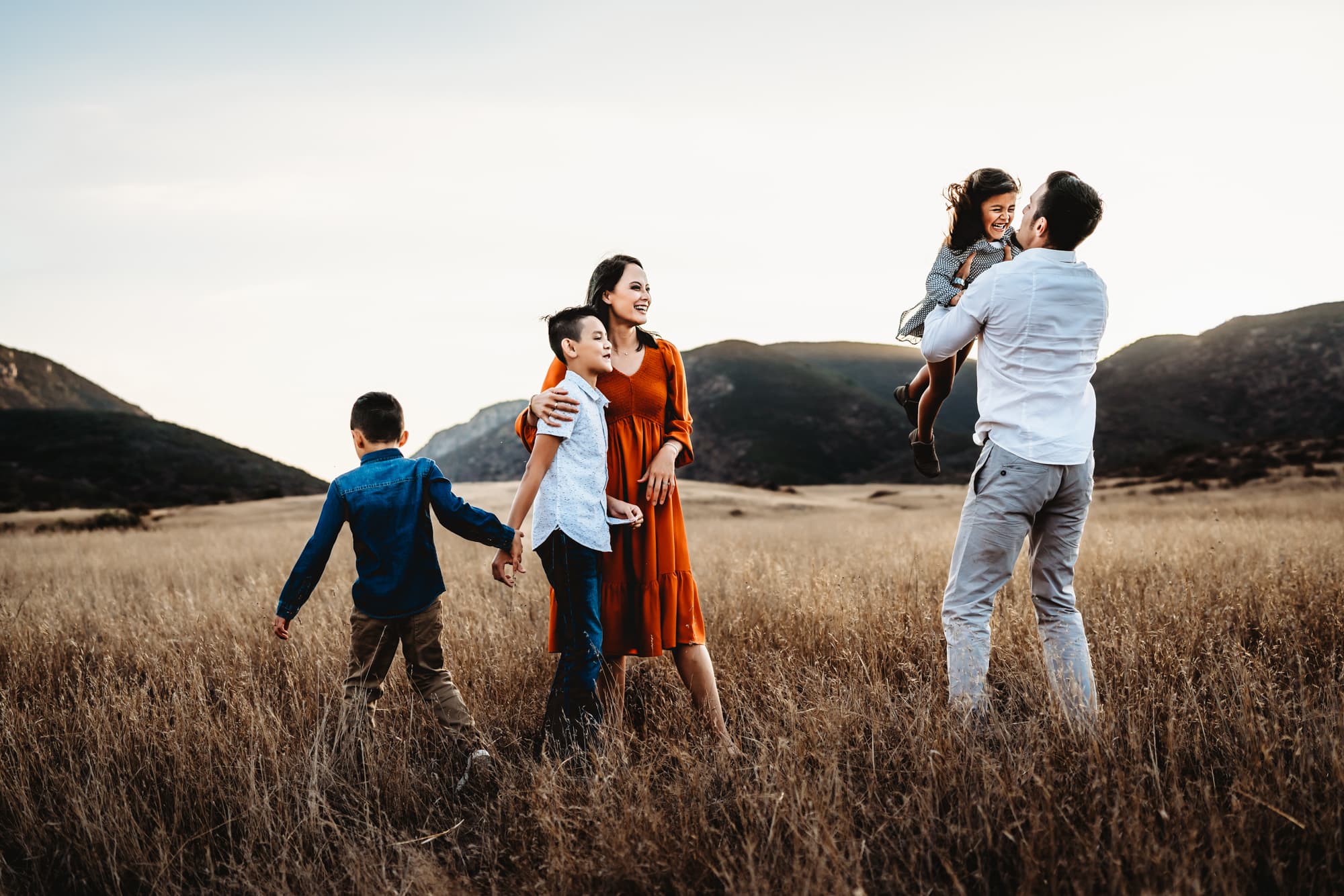 A family of 5 playing in a field in Mission Trails Regional Park during a San Diego lifestyle family photo session by Love Michelle Photography. 