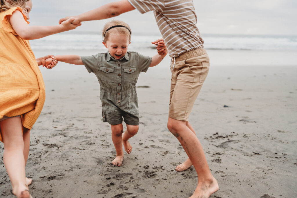 San Diego Family Photographer captures family playing together on beach during best times to visit San Diego