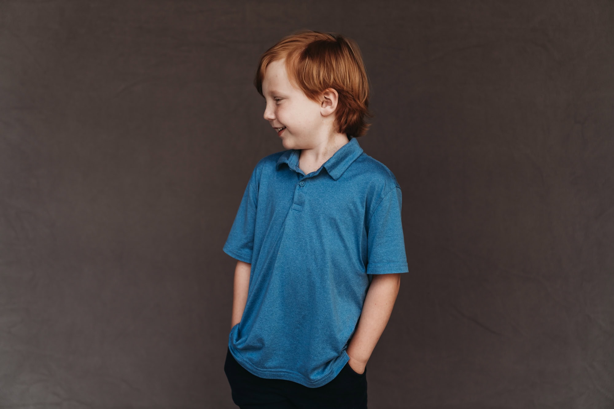 San Diego school photographer fine art homeschool portrait of young boy in blue polo, looking to the side with natural expression.