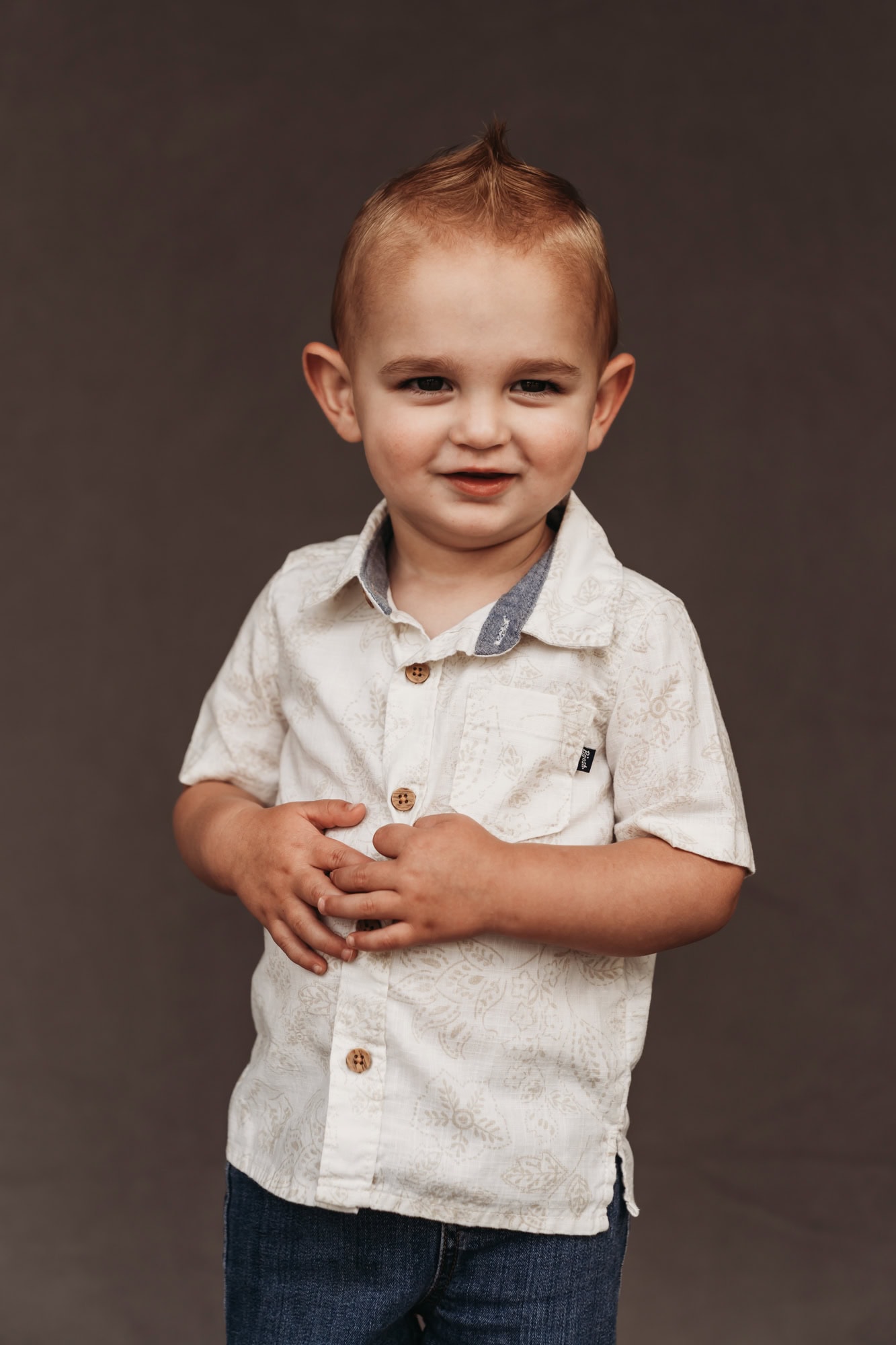 San Diego school photographer homeschool portrait of toddler boy in patterned shirt with faux hawk hairstyle, looking thoughtful.