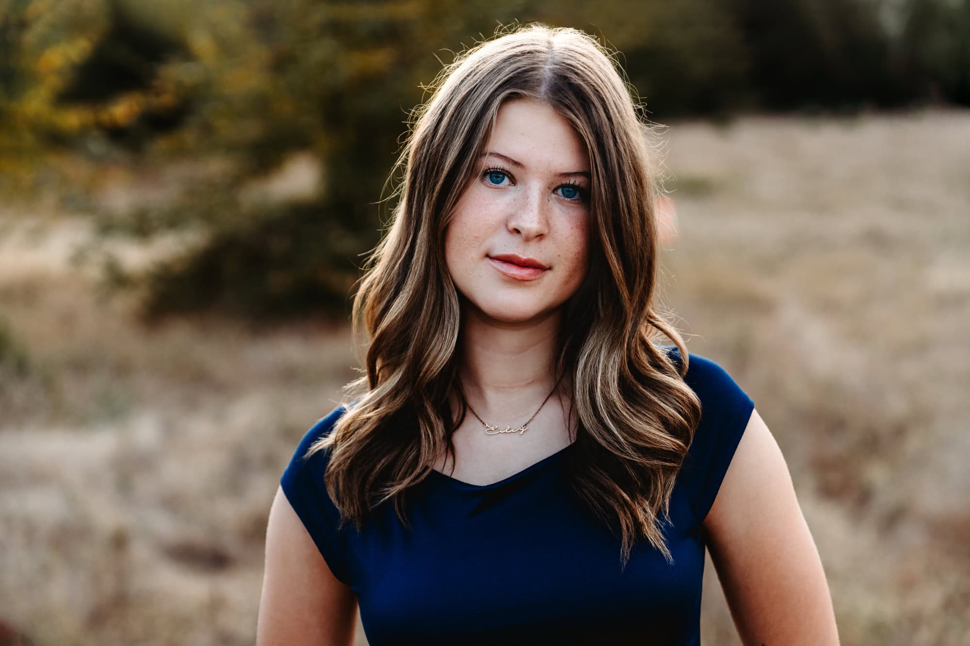 Close-up senior portrait of a girl in a navy top, natural and authentic senior photos in San Diego. 