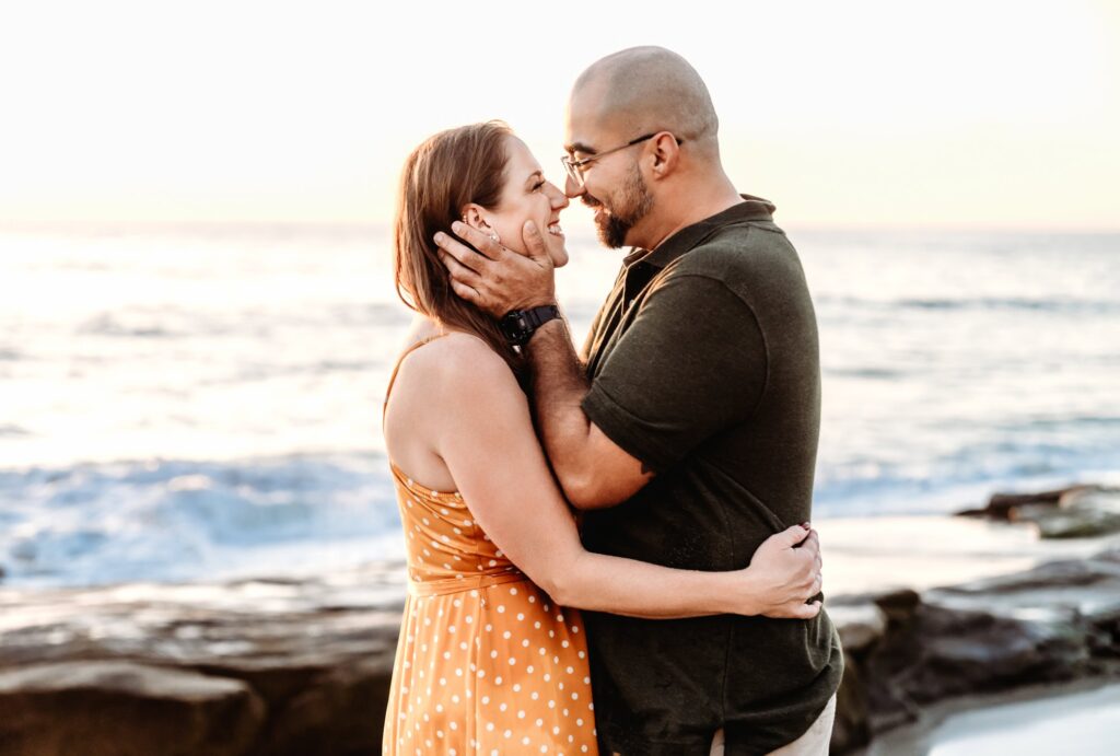 Parents embracing on the beach at sunset, Windansea Beach family photos. 