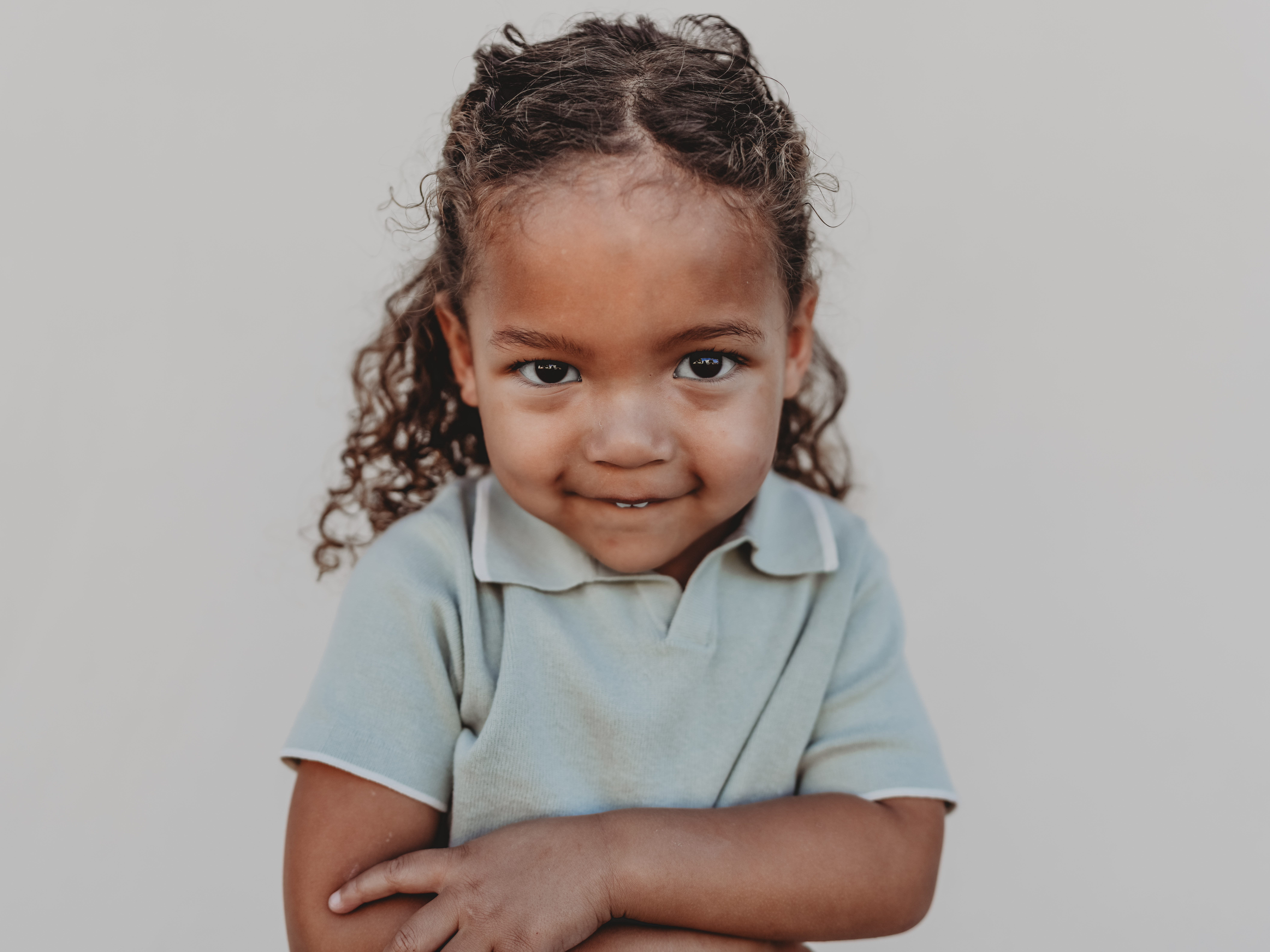 A boy smiles shyly for the camera during school photos at his San Diego Montessori school.