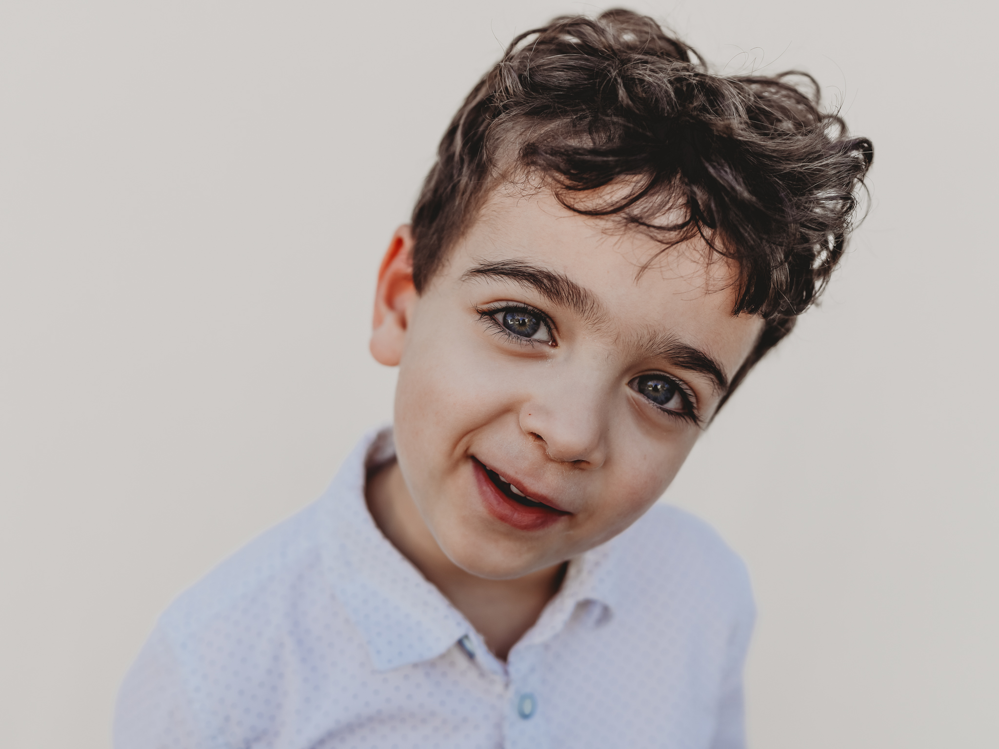 A boy looks quizzically at the camera during photo day with Love Michelle Photography at a San Diego preschool.