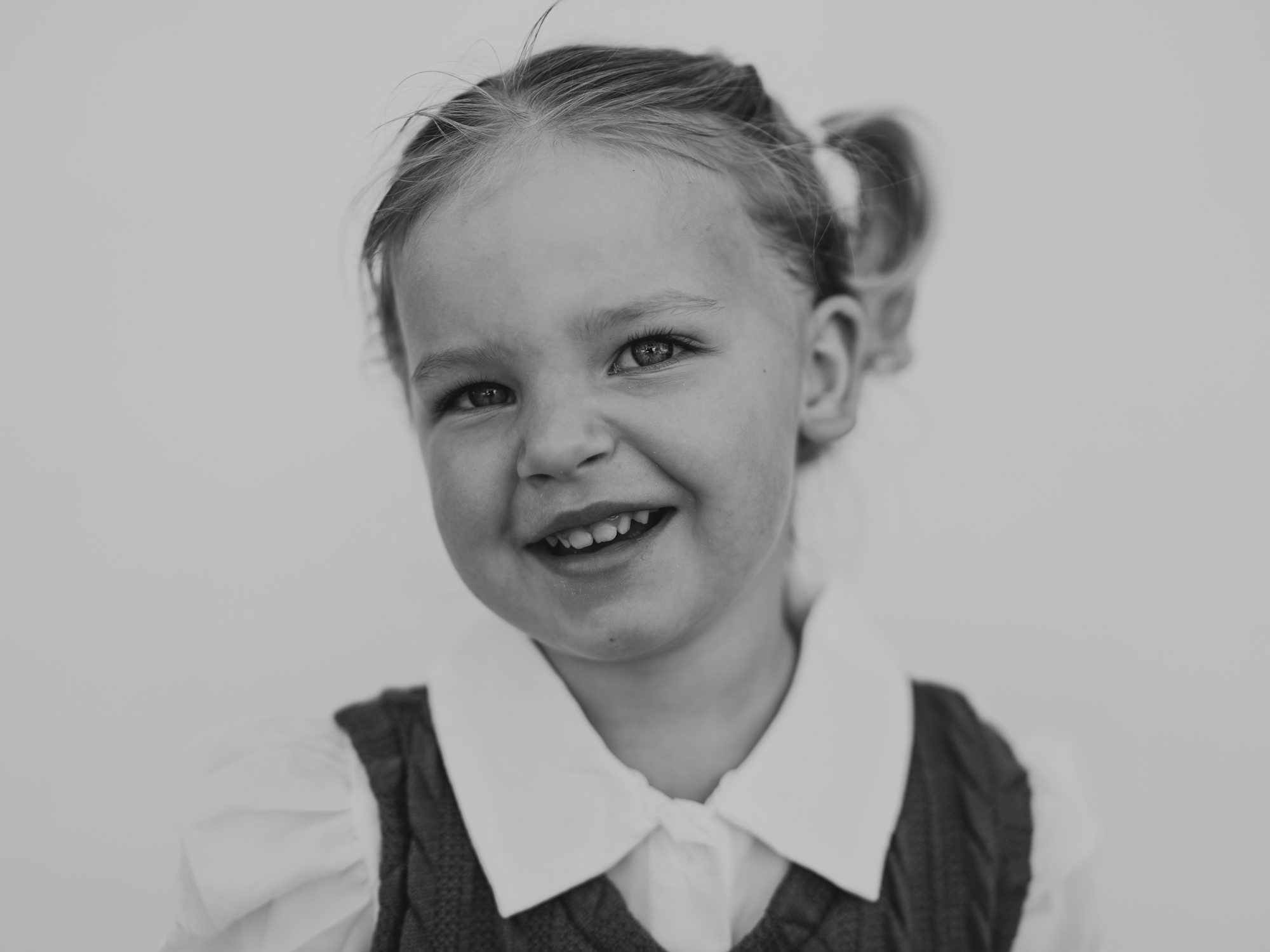 A little girl smiles during photo day at her Montessori school in San Diego.