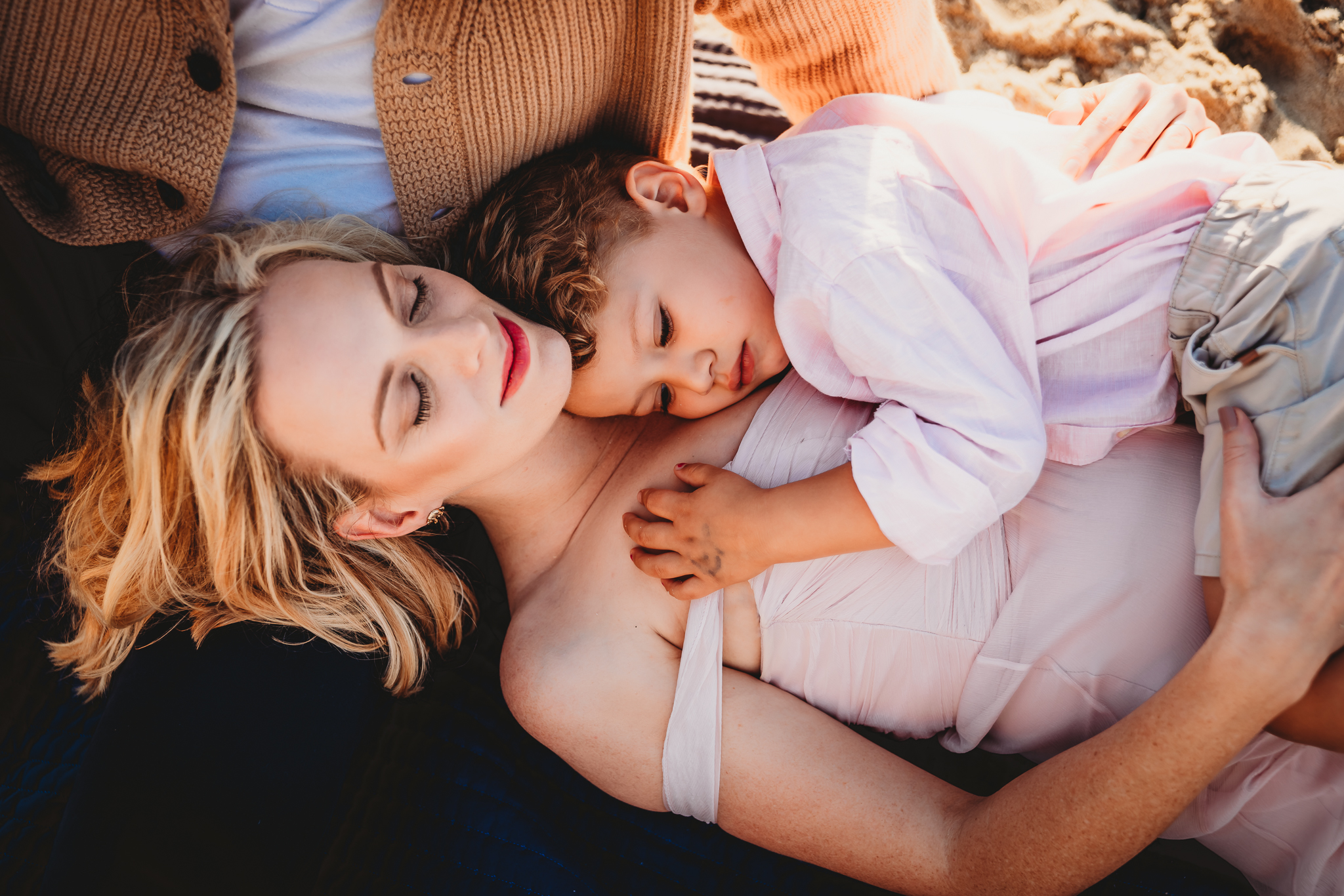 A mom holds her son on her lap during a San Diego family photo session. 
