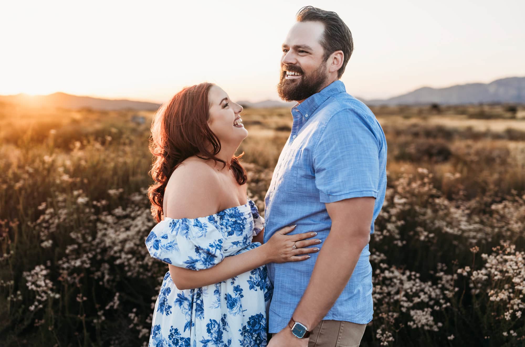 Warm sunset maternity photo of smiling expectant couple in open field in San Diego